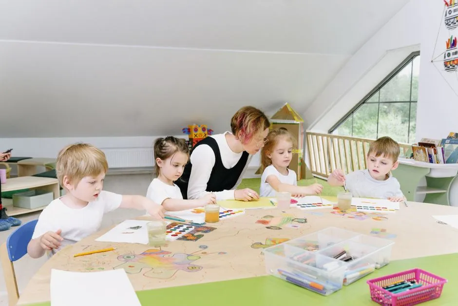 Young children coloring at a table in a classroom setting